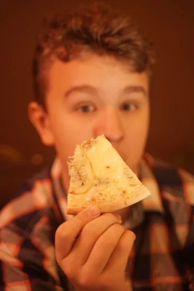 Dospívající chlapec jí pizzu a užívá si ji, detailní záběr těší a vychutnává. — Stock fotografie