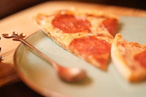 Krájet lahodnou čerstvou domácí pizzu na talíři na stole. klasické peperroni s klobásou. — Stock fotografie