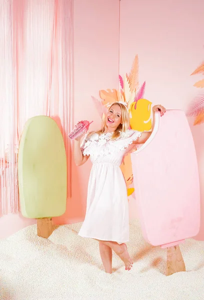 Encantadora mujer rubia feliz en un vestido de verano de encaje suave posando con un enorme helado rosa en la piscina con espuma pequeñas bolas suaves y comprometidos en la terapia de relajación . —  Fotos de Stock