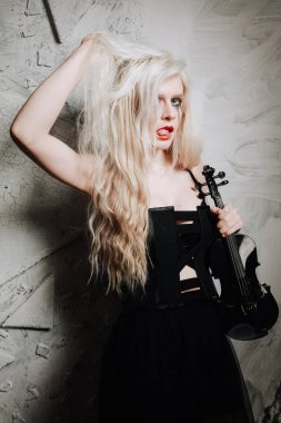 Beyaz arka planda keman çalan sarışın gotik kız. Partideki genç kadın..