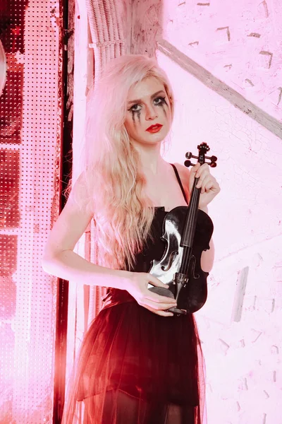 Blondynka gotycka ze skrzypcami na białym tle. Młoda kobieta na imprezie. — Zdjęcie stockowe