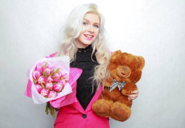 Nazik, sarışın, zayıf, pembe çiçekli genç kız. Taze buketli neşeli kadın