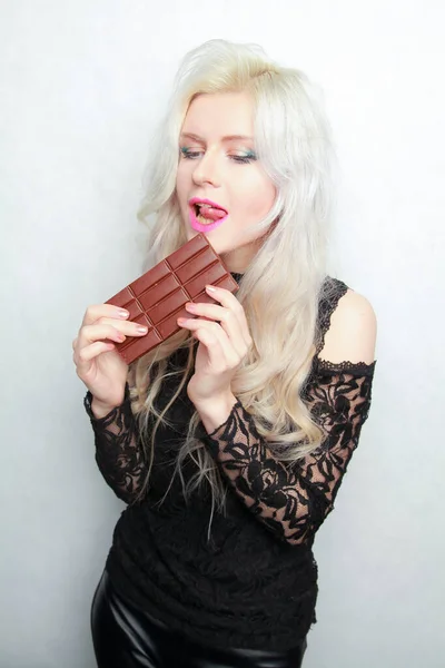 年轻的女孩吃块巧克力孤立的白色背景上 — 图库照片