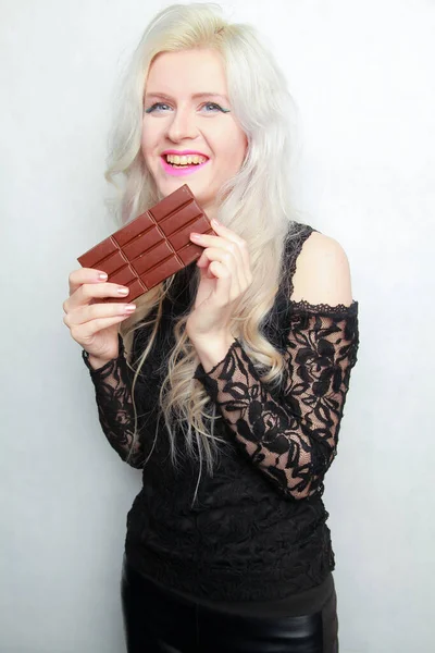 Menina comendo bar de chocolate isolado no fundo branco — Fotografia de Stock