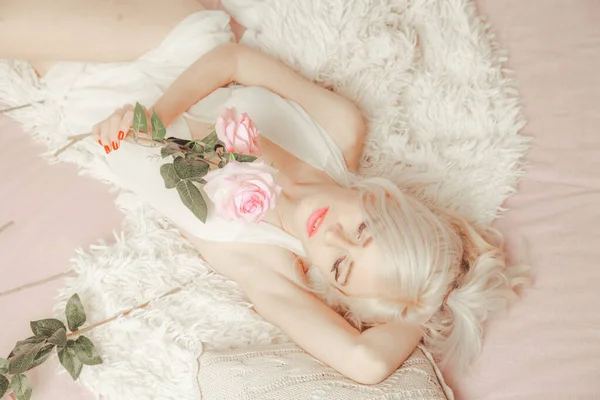 아침에 일어나는 여자. 하얀 침대에 누워 있는 가느다란 금발의 암컷. — 스톡 사진