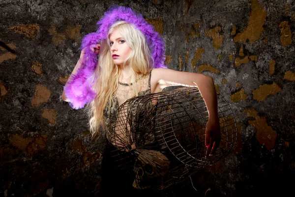 Donker gothic meisje met grote vogel kooi in armen op donkere achtergrond staan alleen — Stockfoto