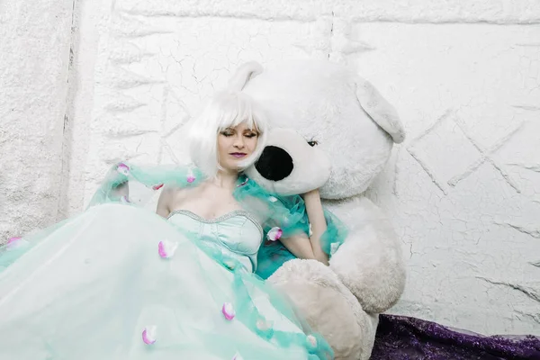 Ładny blondynka dorosły dziewczyna w słodkie niebieski sukienka z Duży biały miś — Zdjęcie stockowe