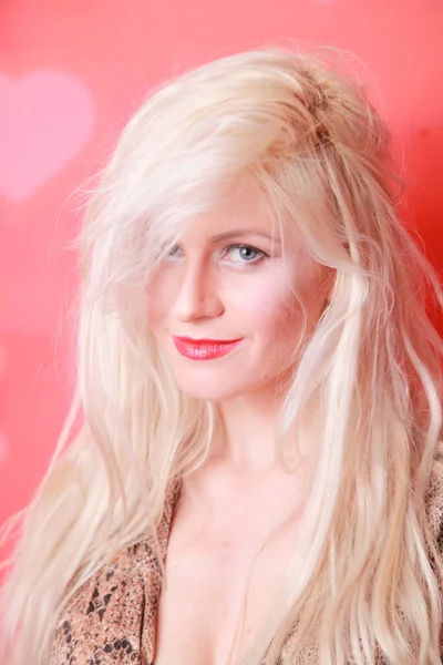 Mulher bonita com cabelo loiro posando no fundo do estúdio vermelho — Fotografia de Stock
