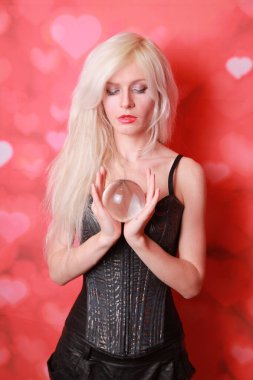 Sihirli genç bir kadın büyük bir kristal küre tutuyor ve kırmızı stüdyoda aşkın geleceğini bilmek istiyor.