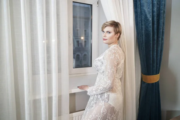 Sexy blonde plus la taille de cheveux courts femme en lingerie robe transparente sur fond de chambre — Photo