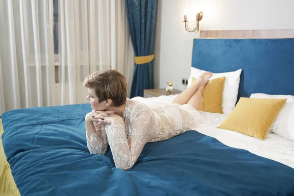 Σέξι ξανθιά συν μέγεθος κοντά μαλλιά γυναίκα σε εσώρουχα διαφανές φόρεμα στο φόντο υπνοδωμάτιο — Φωτογραφία Αρχείου