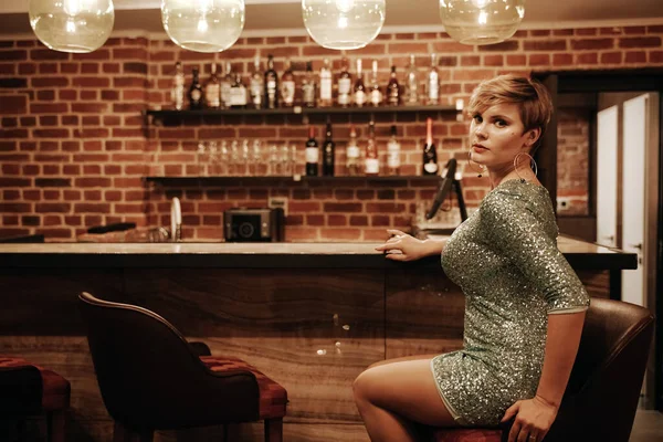 Retrato de mujer joven y bella esperando a alguien en un bar. Además chica de tamaño en un vestido de fiesta de purpurina solo en el café . — Foto de Stock