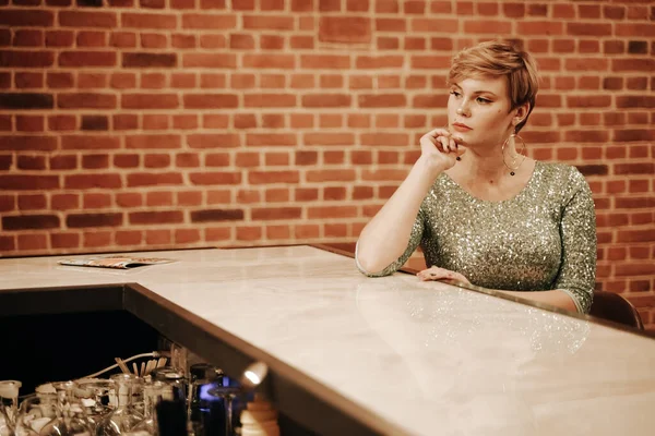 Retrato de mujer joven y bella esperando a alguien en un bar. Además chica de tamaño en un vestido de fiesta de purpurina solo en el café . — Foto de Stock