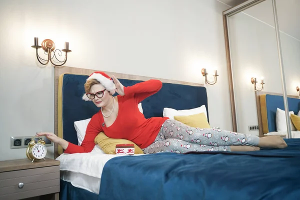 Taille plus femme en chapeau Santa avec rétro-réveil en or dans la chambre — Photo