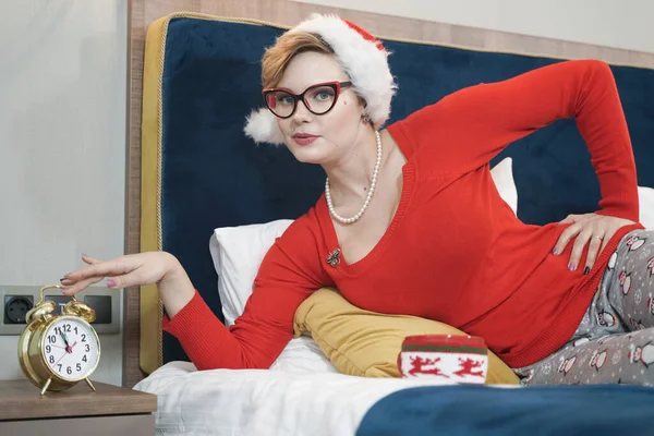 Taille plus femme en chapeau Santa avec rétro-réveil en or dans la chambre — Photo
