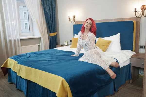 Hermosa novia chica con rojo bob corte de pelo en encaje vestido largo posando en su dormitorio solo — Foto de Stock
