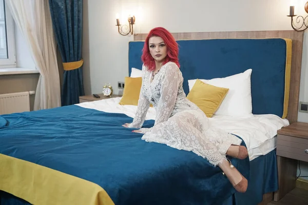 Belle jeune mariée avec bob rouge coupe de cheveux en dentelle robe longue posant dans sa chambre seule — Photo