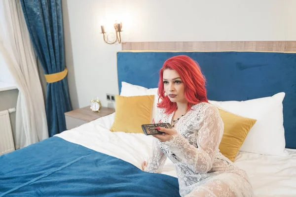 Krásná nevěsta dívka s červeným bob účes v krajky dlouhé šaty pózovat ve své ložnici sám — Stock fotografie