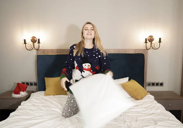 Feliz joven caucásica bonita chica usando Santa suéter y disfruta en el dormitorio solo — Foto de Stock