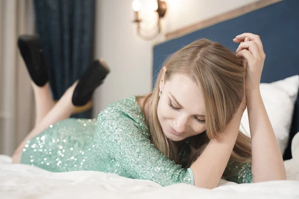 Vacker sexig kvinna liggande på sängen i aftonklänning. Fashion. Interiör. — Stockfoto
