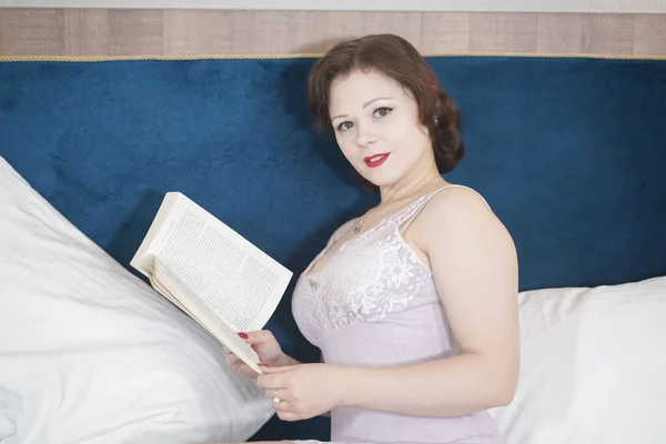 cute retro woman with book enjoy by reading and education on the bed. pretty girl in nightgown in the bedroom.