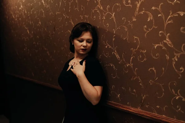 Hermosa mujer pin up en vestido retro contra la pared oscura — Foto de Stock