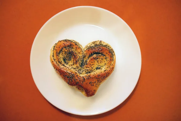 Bollo de San Valentín para el desayuno para los amantes sobre fondo de mesa naranja — Foto de Stock