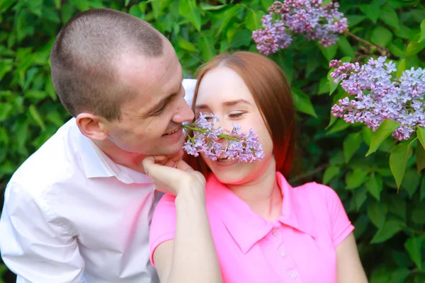 Влюбленные мальчик и девочка позируют в цветах в парке летом — стоковое фото