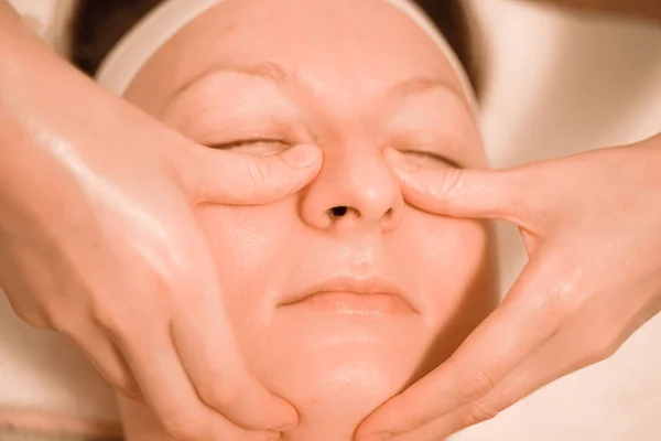 Vacker plus storlek medelålders kvinna får en ansiktsmassage behandling på skönhetssalong. närbild — Stockfoto