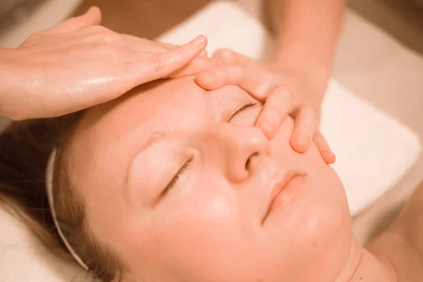 Hermosa mujer de mediana edad más tamaño recibiendo un tratamiento de masaje facial en el salón de belleza. de cerca — Foto de Stock