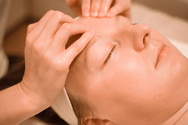 Hermosa mujer de mediana edad más tamaño recibiendo un tratamiento de masaje facial en el salón de belleza. de cerca — Foto de Stock