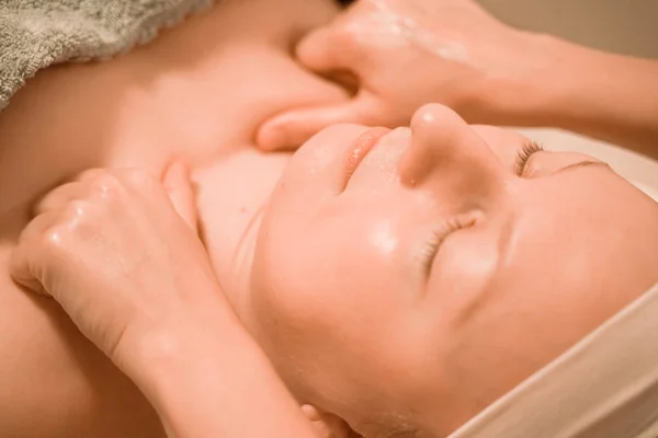 Beautiful plus size middle age woman getting a face massage treatment at beauty salon. close up