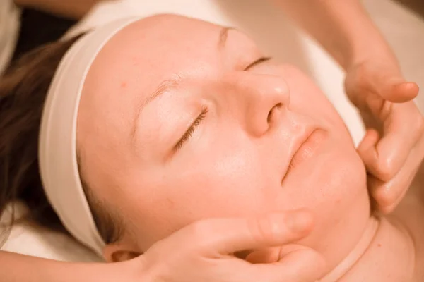 Beautiful plus size middle age woman getting a face massage treatment at beauty salon. close up