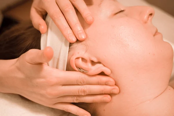 Mulher bonita plus size meia idade recebendo um tratamento de massagem facial no salão de beleza. de perto — Fotografia de Stock