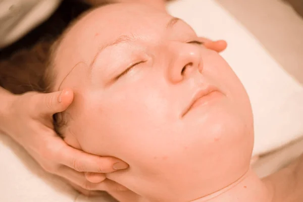 Hermosa mujer de mediana edad más tamaño recibiendo un tratamiento de masaje facial en el salón de belleza. de cerca — Foto de Stock