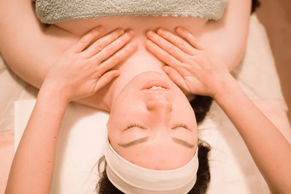 Mooie jonge vrouw het krijgen van een gezicht massage behandeling bij schoonheid salon — Stockfoto