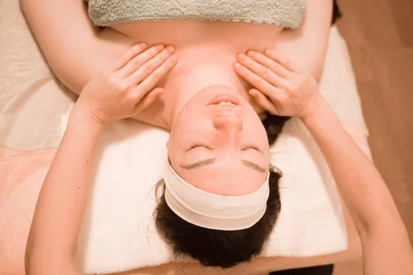 Mulher bonita recebendo um tratamento de massagem facial no salão de beleza — Fotografia de Stock