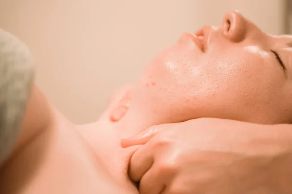 Beautiful young woman getting a face massage treatment at beauty salon — Stock Photo, Image