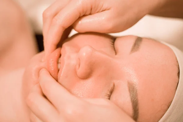 Krásná mladá žena dostat masáž obličeje ošetření v salonu krásy — Stock fotografie