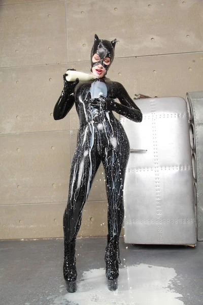 黒ラテックスの猫とコスプレマスクにミルクでポーズをとる女性 — ストック写真