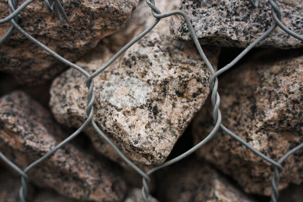 Детальный снимок каменной подпорной стены с камнями в стальной клетке. никто
.
