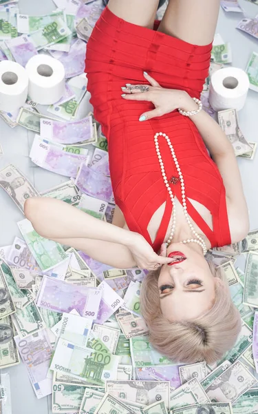 Uma Menina Loira Emocional Vestido Vermelho Está Deitado Dinheiro Espalhado — Fotografia de Stock
