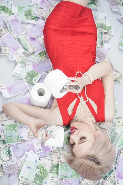 Emocjonalna Blondynka Czerwonej Sukience Leży Rozrzuconych Pieniądzach Papierem Toaletowym Bogata Obraz Stockowy