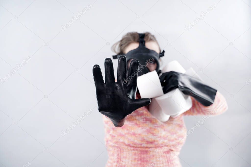 scared woman in a gas mask and gloves takes all the toilet paper from the store during the coronovirus covid epidemic.