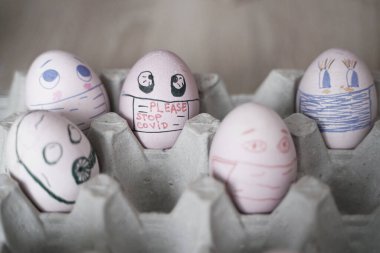 Paskalya tatili dekorasyonu için maske takarak kendin yap. Kopyalama alanı ile seçmeli odak. COVID-19 koruması. Corona virüslü Paskalya yumurtaları COVID19 koruma kavramları.