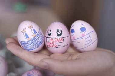 Paskalya tatili dekorasyonu için maske takarak kendin yap. Kopyalama alanı ile seçmeli odak. COVID-19 koruması. Corona virüslü Paskalya yumurtaları COVID19 koruma kavramları.