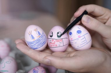 Paskalya tatili dekorasyonu için maske takarak kendin yap. Kopyalama alanı ile seçmeli odak. COVID-19 koruması. Corona virüslü Paskalya yumurtaları COVID19 koruma kavramları.