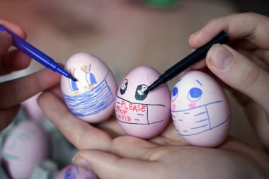 Paskalya tatili dekorasyonu için maske takarak kendin yap. Kopyalama alanı ile seçmeli odak. COVID-19 koruması. Corona virüslü Paskalya yumurtaları COVID19 koruma kavramları.