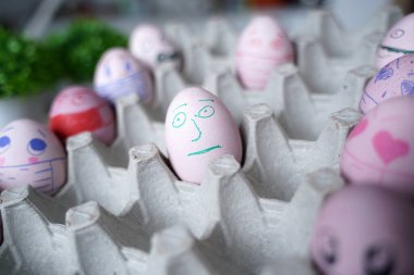 Paskalya tatili dekorasyonu için maske takarak kendin yap. Kopyalama alanı ile seçmeli odak. COVID-19 koruması. Corona virüslü Paskalya yumurtaları COVID19 koruma kavramları.