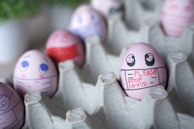 Paskalya tatili dekorasyonu için maske takarak kendin yap. Kopyalama alanı ile seçmeli odak. COVID-19 koruması. Corona virüslü Paskalya yumurtaları COVID19 koruma kavramları.